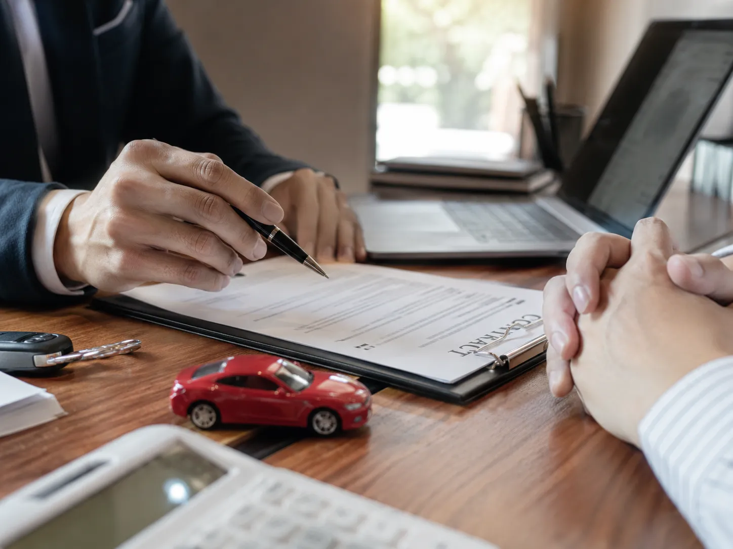 Customer reviewing a vehicle purchase agreement with a sales representative